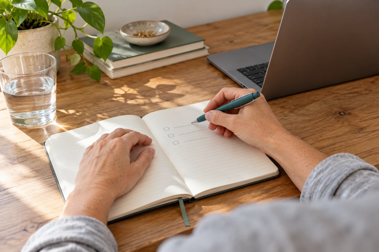 Hands making a short checklist in a notebook.